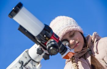 A girl watches the sun through a solar telescope.